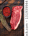 High quality raw striploin steak ready for seasoning, perfect for crafting the ultimate steak dinner experience. wooden background. top view 131939944