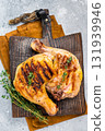 Roast chicken legs with Thigh on wooden cutting board, grilled poultry meat on gray background, top view 131939946