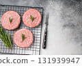 Close up of a juicy raw meat patty cutlet, ideal for crafting mouthwatering sandwiches and savory dishes. white background. top view 131939947