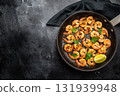 Fried Shrimps Prawns with garlic and butter in a skillet. Black background. Top view 131939948