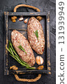 Raw kebabs or kabaps on wooden tray, beautifully arranged and ready to be cooked for a delicious outdoor feast. black background. top view 131939949