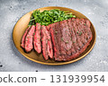 A delectable grilled top sirloin steak served with salad, ready to satisfy your cravings for gourmet cuisine. grey background. top view 131939954