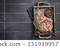 Cooked boiled sliced beef meat in wooden tray. black background. top view 131939957