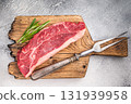 Uncooked striploin steak or strip New York on a wooden cutting board, inviting you to create mouthwatering recipes for any occasion. white background. top view 131939958