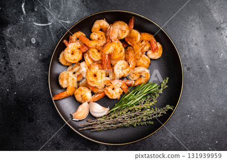 Appetizing grilled shrimp prawns served on a platter, perfect for elegant dinners or casual gatherings with friends. black background. top view 131939959