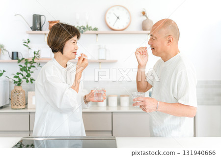 Senior couple brushing their teeth in the kitchen (dental care, bad breath care) 131940666