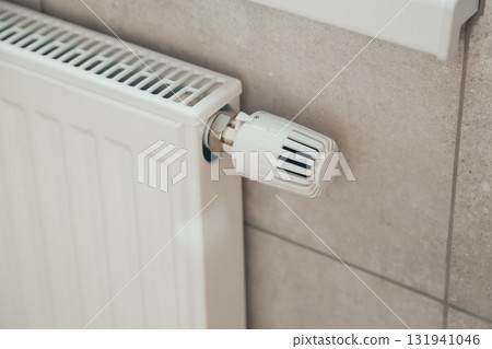 White heating radiator with thermostatic temperature regulator. Heating season. Energy saving White heating radiator with thermostatic temperature regulator. Heating season. Energy saving 131941046