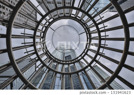 Oct 4 2025 Sleek Glass Skyscraper Behind Spiral Stainless Steel Sculpture 131941623
