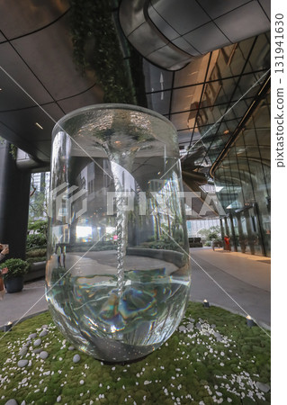 Oct 4 2025 Reflections in a Glass Water Column Sculpture Amid Urban Garden Oct 4 2025 Reflections in a Glass Water Column Sculpture Amid Urban Garden 131941630
