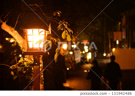 Kinosaki Onsen: Two people standing close together, the townscape at night lit up by the hot spring lights 131942486