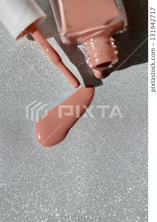 Beige-pink nail polish spilled from a container Beige-pink nail polish spilled from a container 131942717