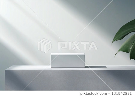 Minimalist product display featuring white rectangular podium on textured surface with tropical plant, ideal for showcasing packaging designs 131942851