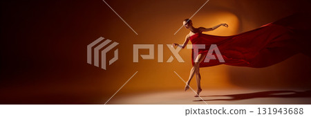 Ballet dancer in red flowing dress performing dynamic motion under orange lighting. Banner Ballet dancer in red flowing dress performing dynamic motion under orange lighting. Banner 131943688