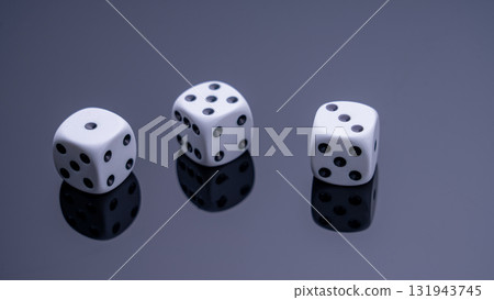 Three white dice are on a black background 131943745