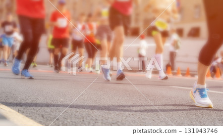 A group of runners are running on a road with a blurry background A group of runners are running on a road with a blurry background 131943746