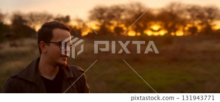 portrait of a young man 20s wearing eyeglasses, set outside agai portrait of a young man 20s wearing eyeglasses, set outside agai 131943771