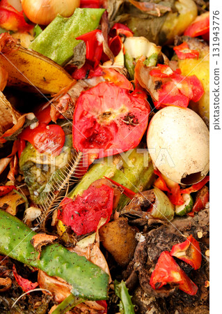 A vibrant closeup of a domestic compost bin filled with organic waste and food scraps for recycling. The pile, heap clearly features a red tomato and egg shells A vibrant closeup of a domestic compost bin filled with organic waste and food scraps for recycling. The pile, heap clearly features a red tomato and egg shells 131943776