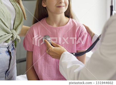 Close-up pediatric exam with stethoscope on child's chest during clinic checkup Close-up pediatric exam with stethoscope on child's chest during clinic checkup 131944602