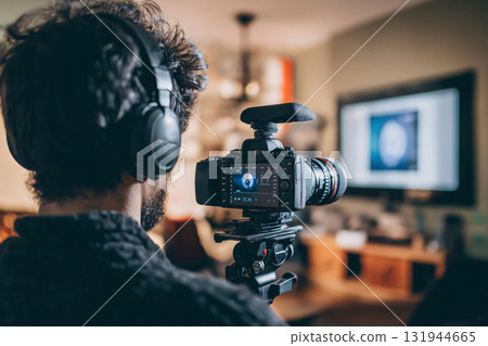 Videographer is recording a video interview with a professional camera at home 131944665