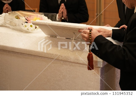 The chief mourner closes the small window in the coffin The chief mourner closes the small window in the coffin 131945352