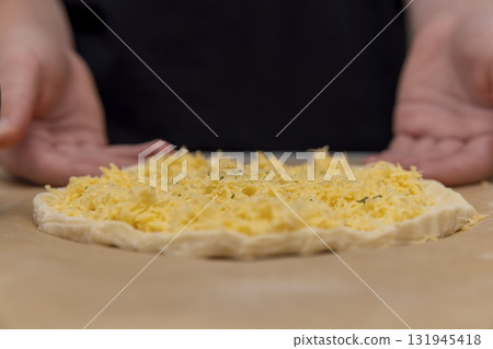 cheese tortilla made of yeast dough and grated cheese, thinly yeast dough sprinkled with yellow hard grated cheese cheese tortilla made of yeast dough and grated cheese, thinly yeast dough sprinkled with yellow hard grated cheese 131945418