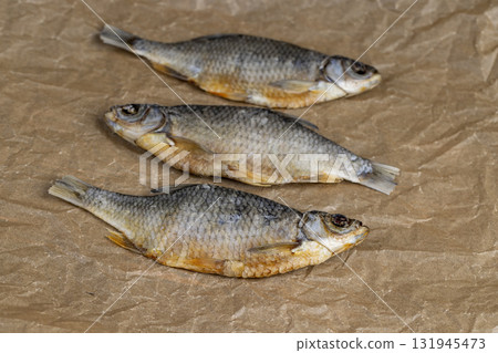 dried fish for long-term storage by dehydrating whole fish in the sun, product of dehydrated and dried fish in scales ready for human consumption 131945473