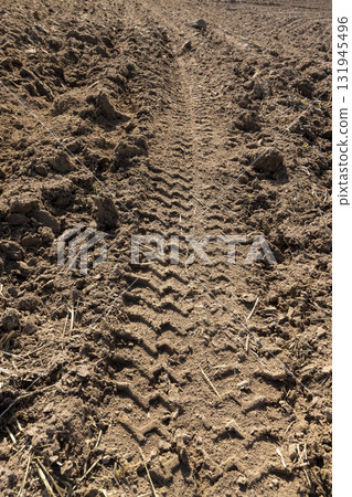 traces of a tractor on a field during tillage, soil in a field with traces of passing heavy agricultural machinery after tillage traces of a tractor on a field during tillage, soil in a field with traces of passing heavy agricultural machinery after tillage 131945496