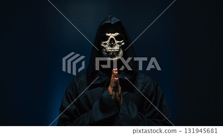 Praying Hands Wearing Hooded Robe in Blue Light 131945681