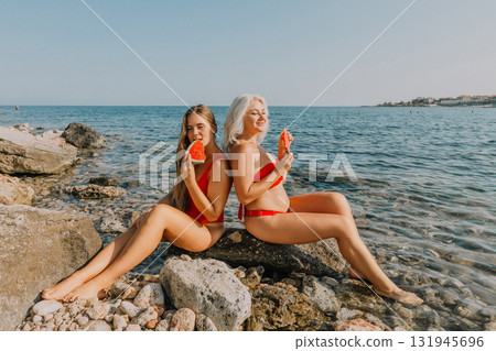 Watermelon Beach Summer: Two Women Enjoying Refreshing Watermelon Slices on Rocky Coastline Watermelon Beach Summer: Two Women Enjoying Refreshing Watermelon Slices on Rocky Coastline 131945696
