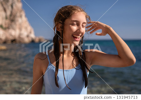 Teenager, beach, summer, happy young woman enjoying a sunny day by the ocean with wet hair Teenager, beach, summer, happy young woman enjoying a sunny day by the ocean with wet hair 131945713