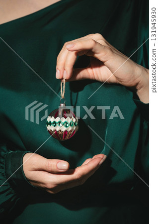 Closeup of woman's hands holding old vintage Christmas glass ornament 131945930