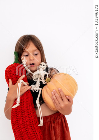 Young caucasian girl holding knitted pumpkin and Halloween skeleton with copy space for text Young caucasian girl holding knitted pumpkin and Halloween skeleton with copy space for text 131946172