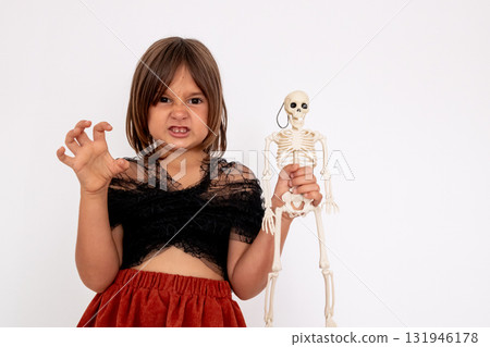 Young caucasian girl with skeleton toy making a fierce gesture Young caucasian girl with skeleton toy making a fierce gesture 131946178