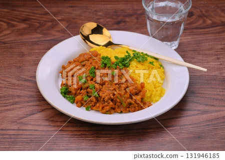 Homemade dry curry with minced beef and pork, onions and peppers (turmeric rice) 131946185