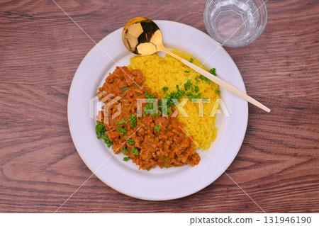 Homemade dry curry with minced beef and pork, onions and peppers (turmeric rice) 131946190