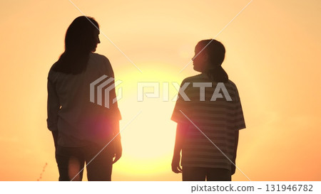 happy family, mother holding child hand outdoors, parent girl child, Mom and kid walking at sunset, holding hands silhouette, outdoor nature scene, happy family feeling, childhood dream horizon, relax 131946782