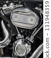 Close look at a polished motorcycle engine part showcasing intricate design and detail in a garage setting 131948359