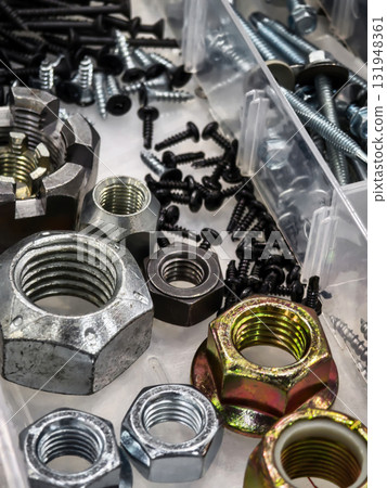 Variety of nuts and bolts organized in storage containers on a workspace 131948361