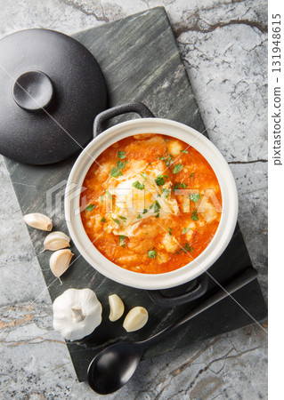 Bread cod garlic soup or zurrukutuna is what comfort food is all about closeup in the saucepan. Vertical top view Bread cod garlic soup or zurrukutuna is what comfort food is all about closeup in the saucepan. Vertical top view 131948615