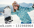 Cheerful smiling woman with snowboard in snowy mountains 131948964