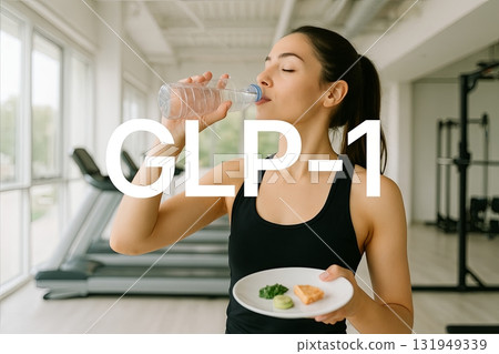 GLP1 concept with woman drinking water while holding plate with healthy food 131949339