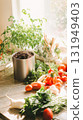 Indoor compost setup with fresh vegetables and herbs on kitchen counter 131949403