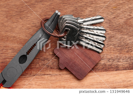 House keys and construction tool pliers on a wooden table. Apartment renovation set House keys and construction tool pliers on a wooden table. Apartment renovation set 131949646