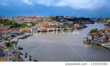 A wide, panoramic, high-angle view of the Douro River flowing through the cities of Porto and Vila Nova de Gaia in Portugal. A wide, panoramic, high-angle view of the Douro River flowing through the cities of Porto and Vila Nova de Gaia in Portugal. 131950390