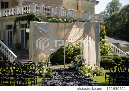 Elegant wedding ceremony venue with draped fabric and floral decorations Elegant wedding ceremony venue with draped fabric and floral decorations 131950821