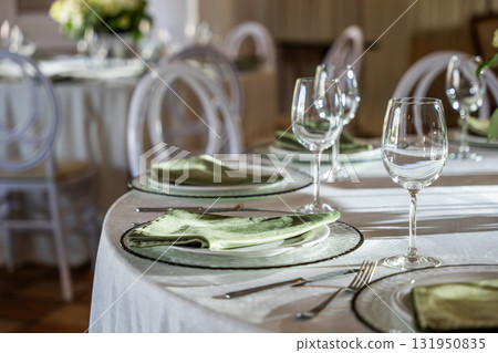 Elegant wedding banquet hall table setting with decorative glassware and linens Elegant wedding banquet hall table setting with decorative glassware and linens 131950835