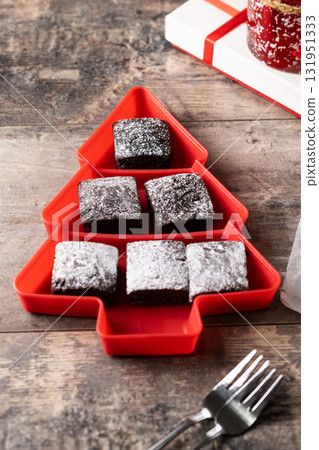 Chocolate brownies with powdered sugar in Christmas tree tray 131951333