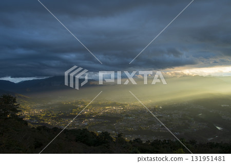 Light pouring through the clouds onto the town of Chichibu (Angel's Ladder/Crepuscular rays) 131951481