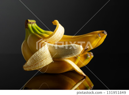 Bananas on a black reflective background. 131951849