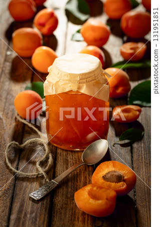 Apricot jam and fresh fruit on an old wooden table. 131951851
